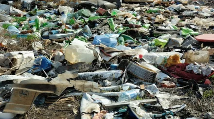 Тяжелая техника расчищает завалы мусора во дворе "плюшкина" в Усть-Каменогорске